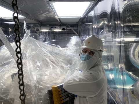 Chris Nedlik, who received his Ph.D. in physics at UMass, works onsite and nearly a mile underground in a temporary clean-tent constructed to unwrap the LZ time projection chamber.  Image credit: UMass Amherst 