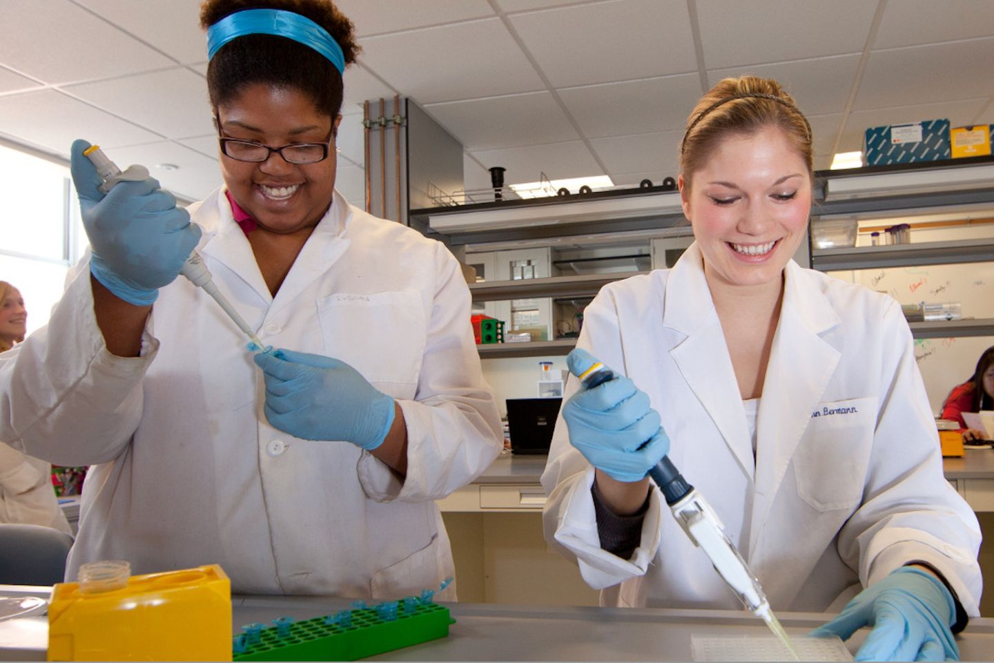 Two UMass students working in a research lab with samples.