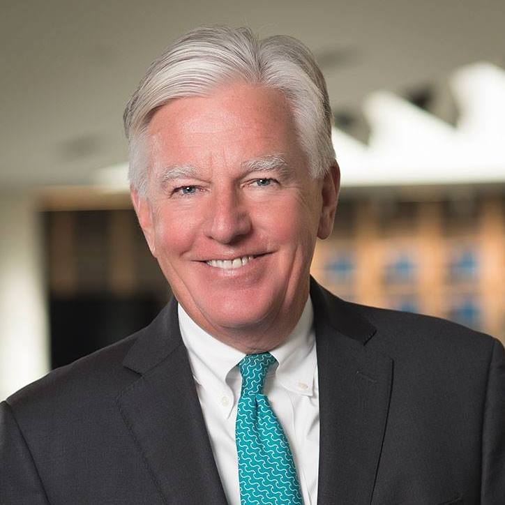 Headshot of Umass President Marty Meehan smiling at the camera wearing a suit and tie.