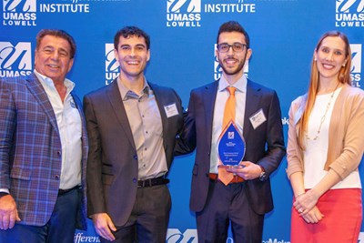 Senior biology major Adam Iskandar holds Team Amara's Rist Campus-wide DifferenceMaker award alongside, from left, program namesake Brian Rist '77, teammate Brandon Conceicao and DifferenceMaker Director Holly Lalos during the $50,000 Idea Challenge at Moloney Hall.