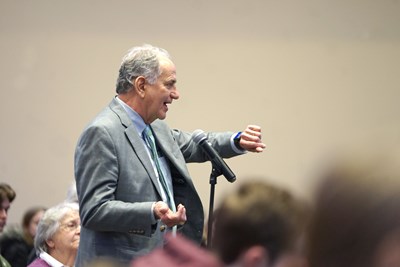 James Sherwood, dean of the Francis College of Engineering, asks a question while holding up his Apple Watch during the WHOOP presentation.