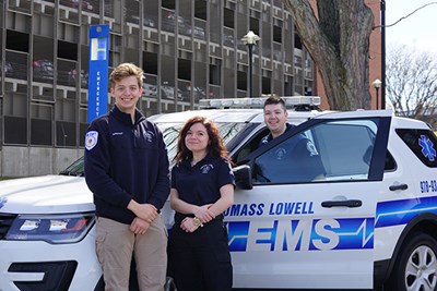 EMTs, from left, Andrew Finerty, Angela Piso and P.J. Roe stand in front of UMass Lowell EMS car