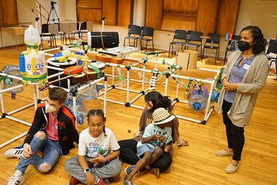 Psychology Assoc. Prof. Rocio Rosales observes as Johnson-Green reads a story to the campers.