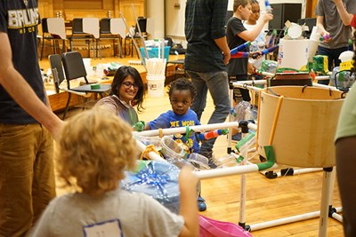 Tanmai Velicheti, a master's student in applied behavior analysis and autism studies, plays music with a young camper.