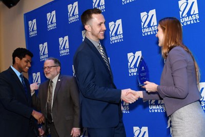 DifferenceMaker Director Holly Lalos shakes hands with Benjamin McEvoy '21 after he and his teammate Edward Morante '20, left, won the 2019 Idea Challenge with their Benji Ball project.