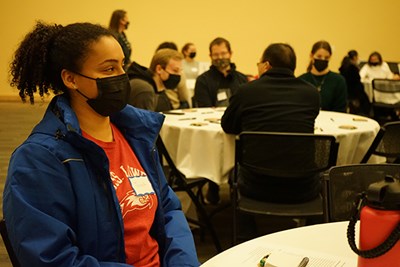 Honors business student Jennifer Dossantos listens to a professor's pitch at the first Honors College mixer to match students with faculty for research.