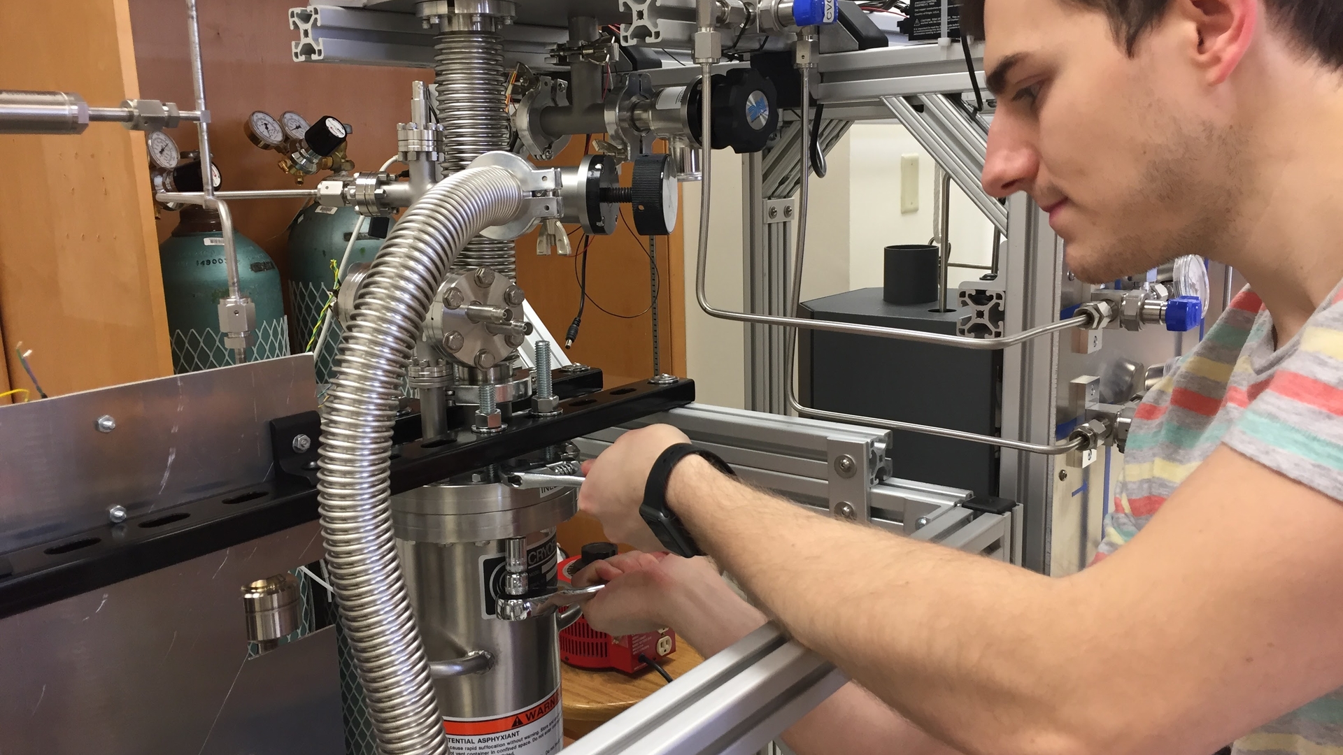 Chris Nedlik who received his PhD in physics at UMass, sealing liquid xenon in the UMass model of the LZ detector that he and Scott Hertel built in Hertel’s lab. Image credit: UMass Amherst