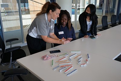 Office of Student Activities and Leadership Assistant Director Jessie Santer goes over Instagram Reels with club leaders Dorcas Ruhamya and Yemi Shimomoto.