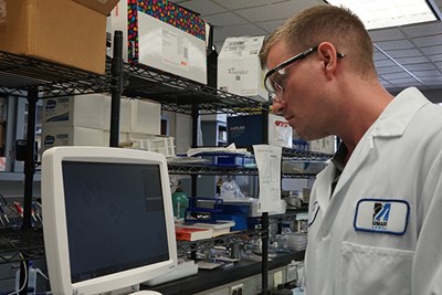 Honors biology and chemical engineering graduate Michael Doane works on a computer in a lab