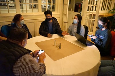 Students from Mill City Consulting, a venture created in their Internship in Entrepreneurship course, share their ideas to attract more students with Cobblestones owner Scott Plath, left, during a meeting at the restaurant.