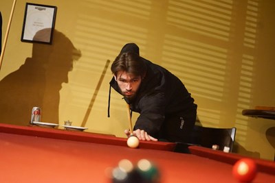 A Manning School of Business student lines up a shot while playing pool at Cobblestones.
