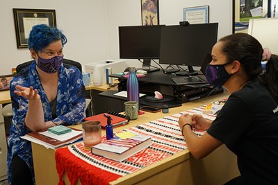 Associate Director of Honors Scholarship and Curriculum Rae Mansfield talks with a former student, honors English major Carolina Reyes.