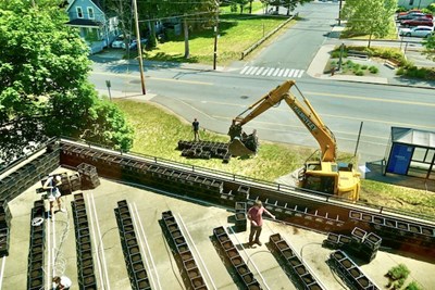 An excavator lifts milk crates filled with compost onto the rooftop terrace at O'Leary.