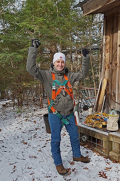 Professor Oberst wears a safety harness while preparing to climb in Harvard Forest