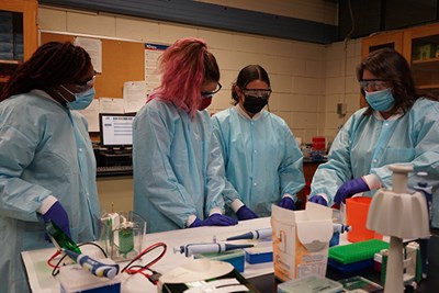 Pharmaceutical sciences major Khadija Sinkinah, left, nutritional sciences major Sadie Reppucci and Ciaramitaro listen to Biomedical Lab Specialist Kellee Cardaleen.