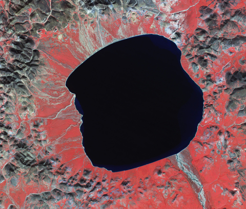 False-color image of Lake El’gygytgyn, taken by the Advanced Spaceborne Thermal Emission and Reflection Radiometer (ASTER) on NASA’s Terra satellite on August 18, 2008 (red indicates vegetation, gray-brown indicates bare land, and deep blue indicates water). 