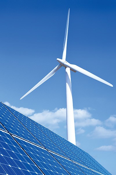 A windmill behind solar panels