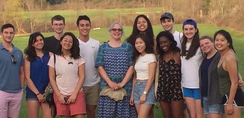 Peg Riley stands next to students