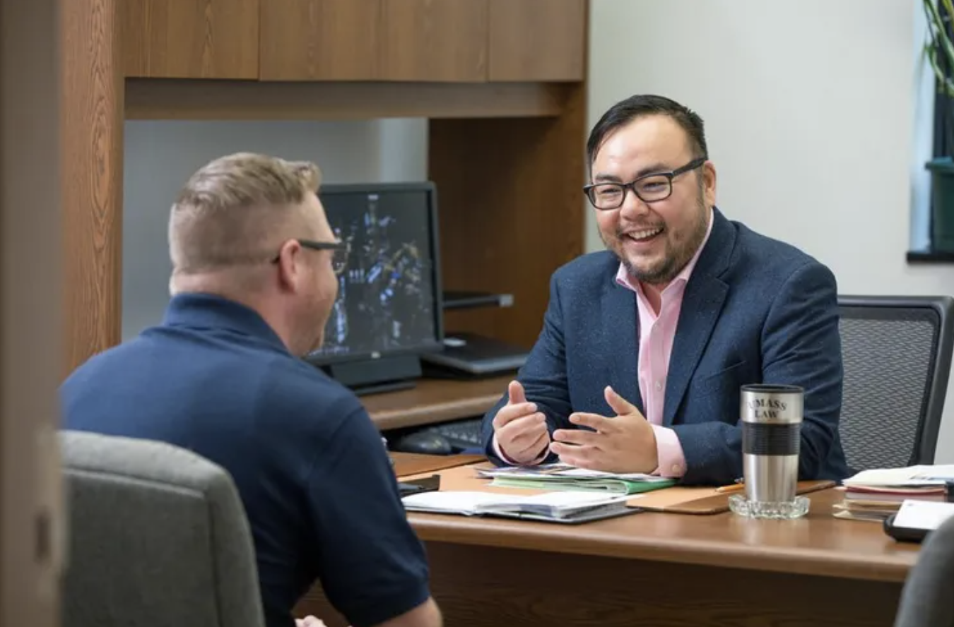 Associate Professor of Law Jeremiah Ho speaks with student in his office