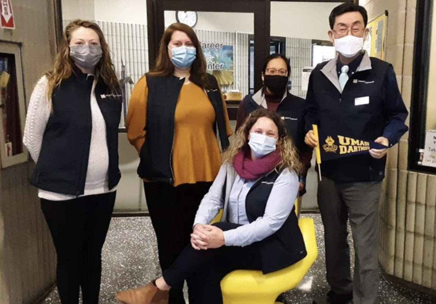 Five members of the UMass Dartmouth Career Center staff wear masks and smile at the camera