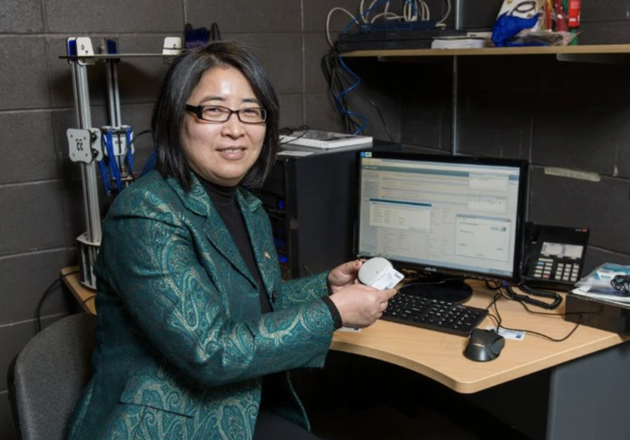 Dr. Hong Liu sits in front of a computer in her office