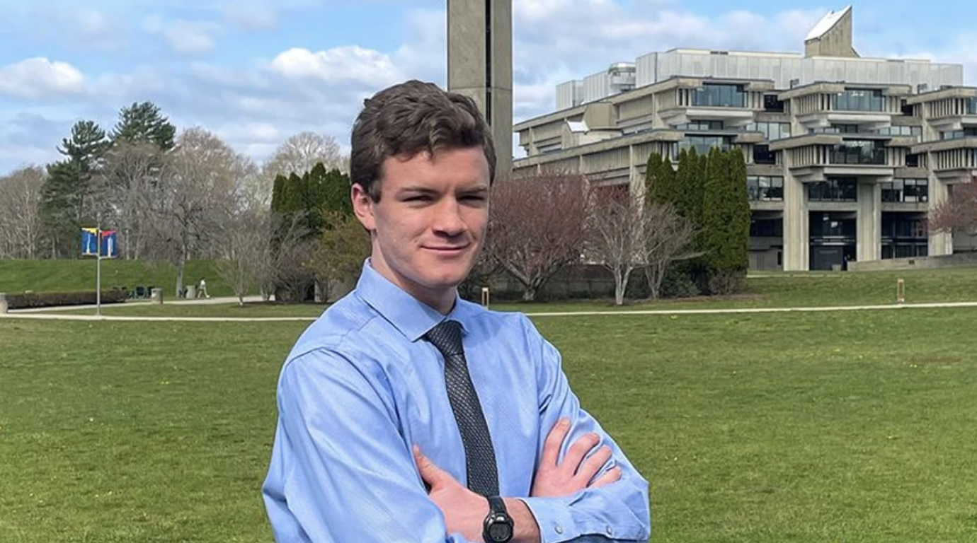 Maxwell White stands in front of UMass Dartmouth library