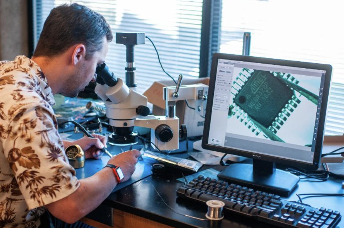 An engineering student looks into a microscope