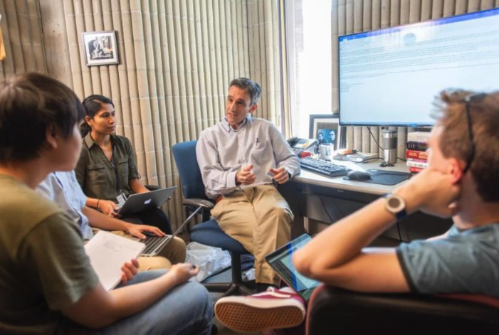 A professor speaks with 5 students in his office