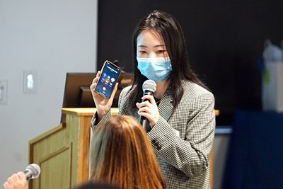 Electrical engineering Ph.D. student Lidan Cao lets ALLL Enterprise Corp. CEO Alice Lin answer a question from judges on speaker phone.