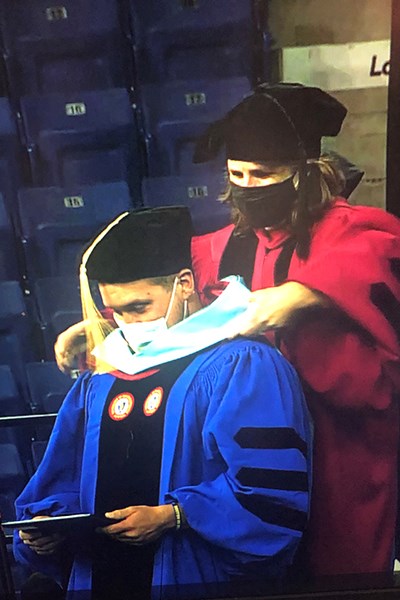 Szczesiul hoods John Braga at Commencement 2021.