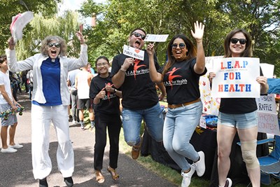 UMass Lowell students and teachers jump in the air with big smiles on their faces