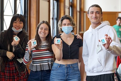 Four students attending symposium smile at camera