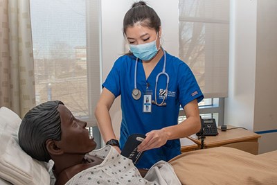 Nursing student practices nursing skills in nursing simulation lab