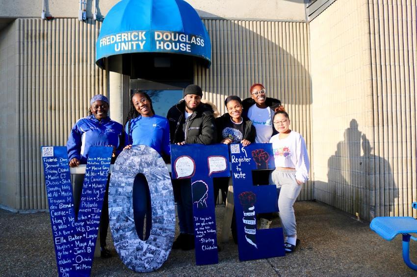 Students stand with VOTE sculptures