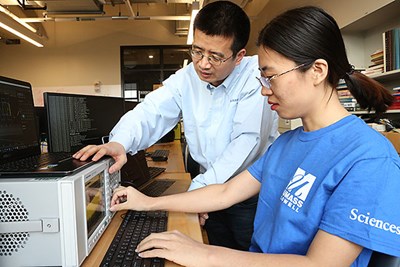 Computer Science Prof. Xinwen Fu, left, works with a graduate student at the UMass Lowell Cyber Range near East Campus.
