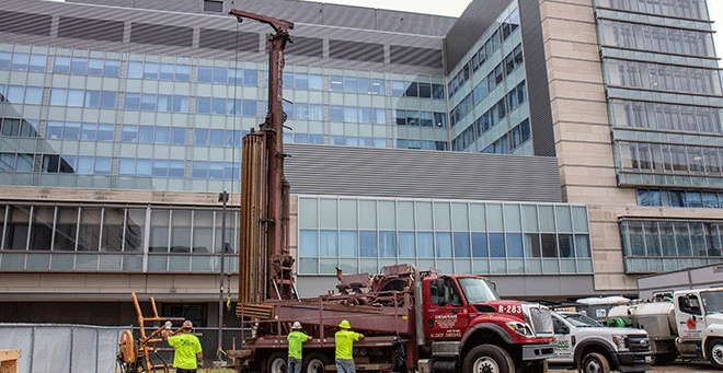 Borehole drilling (seen here) began on July 1 and is expected to continue through the summer. Once complete, the entire system of boreholes and pipe loops will be buried deep under the turf.