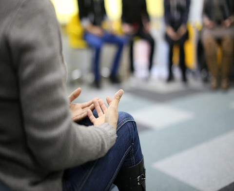 Stock image of someone speaking in group therapy