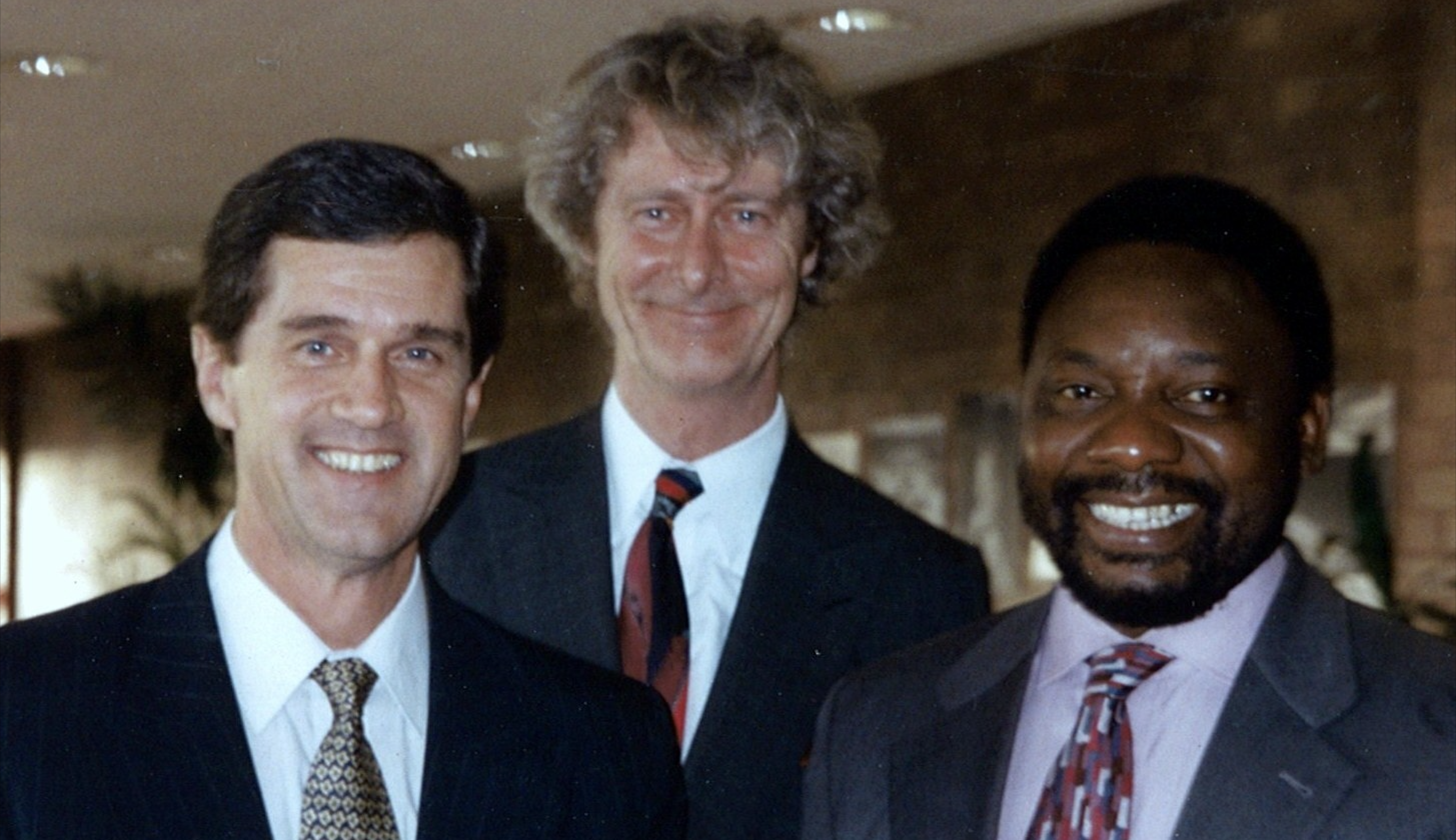 3 men smiling wearing suits