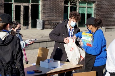 After Hours employee Silvana Davaiga, right, collects food donations for the Navigators Food Pantry from customers Karedis Robles, left, and Joey Peluso.