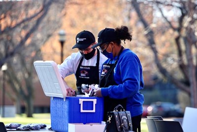 Alec Itzaina and Silvana Davaiga grab panini sandwiches from a cooler for After Hours customers.