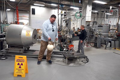 Radiation Safety Office staff members Christopher Tavares, left, and Steven Snay give a tour of the research equipment used in the basement of Pinanski Hall.
