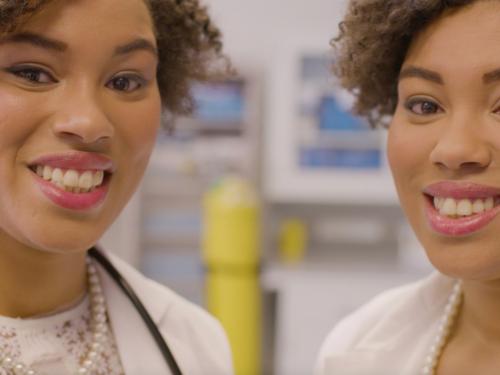 Two female healthcare professionals smile at the camera