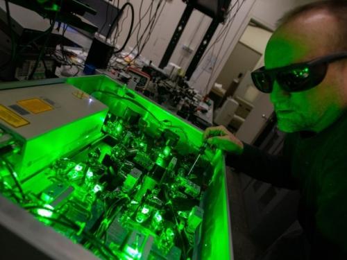 A male researcher wears sunglasses as he works on Broad Spectrum Molecular Imaging at UMass Boston.