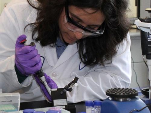 A female researcher works in the Next Generation Sequencing (NGS) & Genomics Lab at UMass Lowell