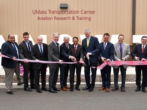 Members of UMass and Massachusetts government leadership cut the ribbon in front of the new UMass Transportation Center