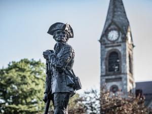 A photo of UMass Amherst with the Minuteman statue and Old Chapel