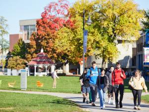 Students walking on the UMass Lowell campus during the fall season.
