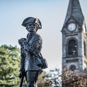 A photo of UMass Amherst with the Minuteman statue and Old Chapel