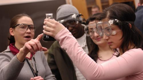 Group of students work in lab together and examine beaker