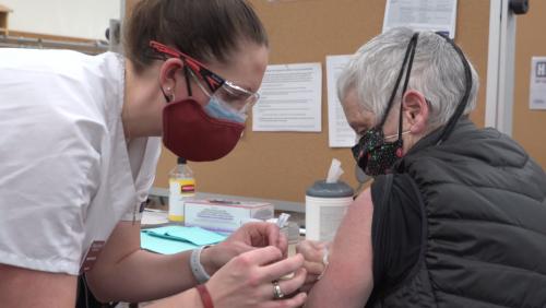 Nurse administering vaccine shot to patient